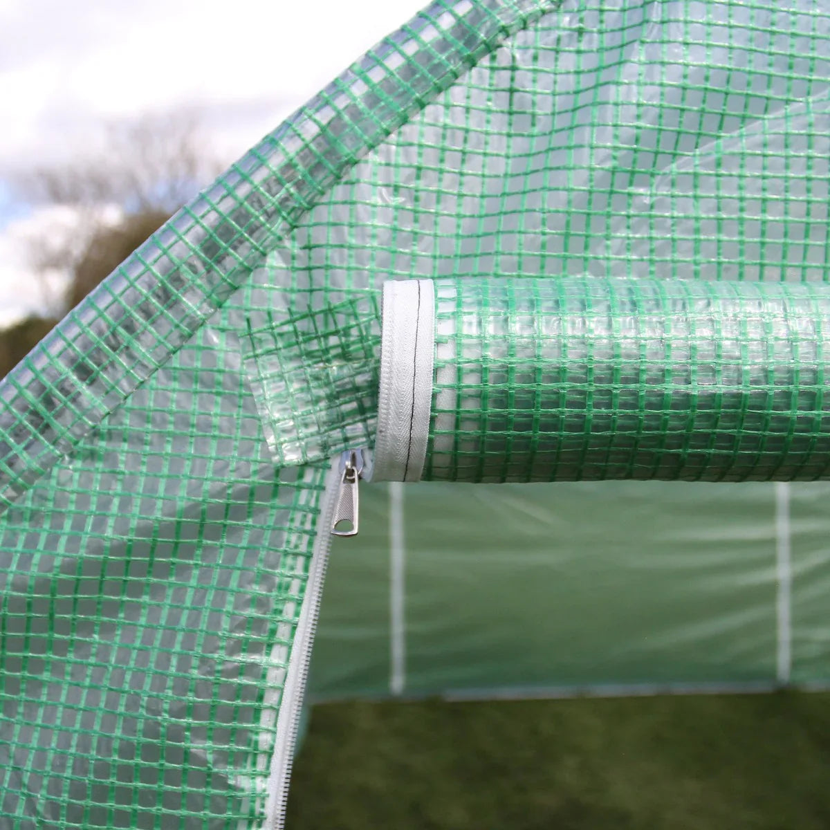 Transparent green polytunnel with a textured surface, featuring a zip closure for easy access, ideal for gardening and plant protection