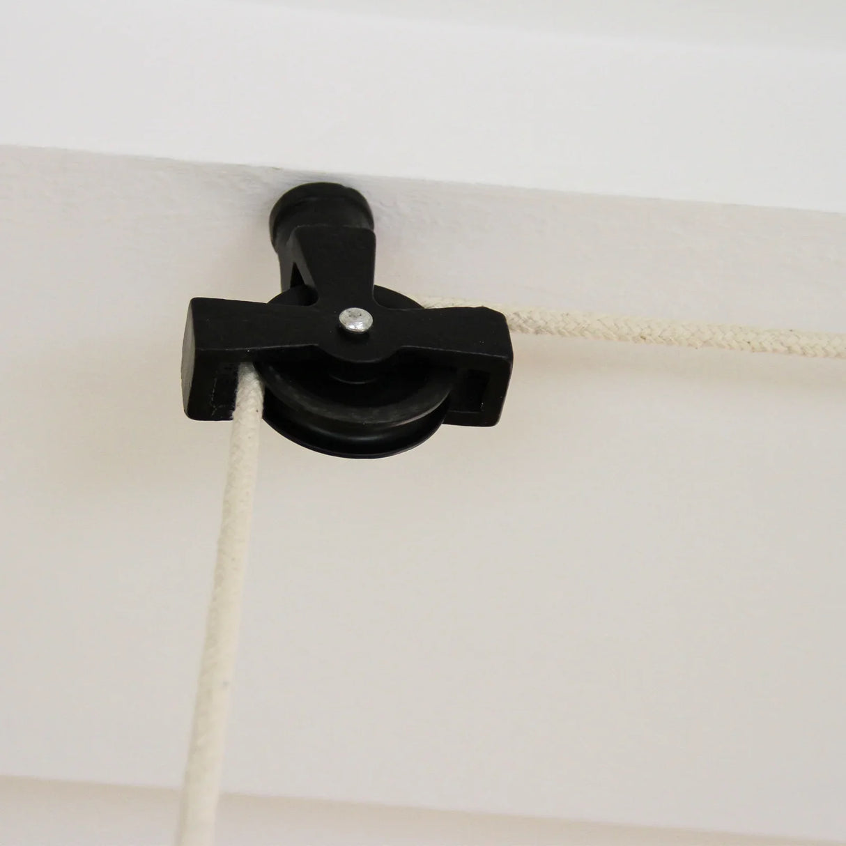 Black ceiling pulley for a clothing airer, featuring a sturdy plastic wheel and durable rope, designed for efficient drying