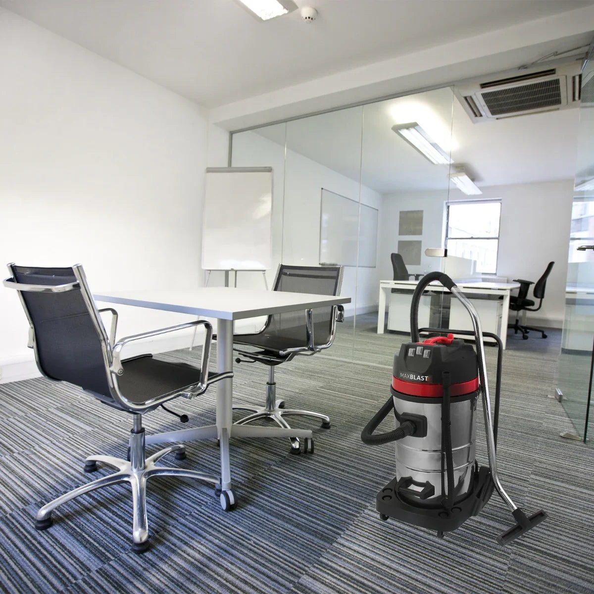 MAXBLAST 80L Industrial Vacuum Cleaner in a modern office setting, featuring a stainless steel body, red accents, and a sturdy design