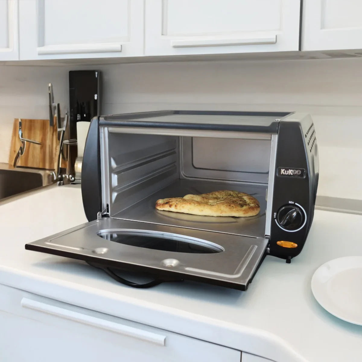 Compact Mini Tandoor Oven with a sleek black exterior, stainless steel interior, and freshly baked naan inside on a kitchen countertop