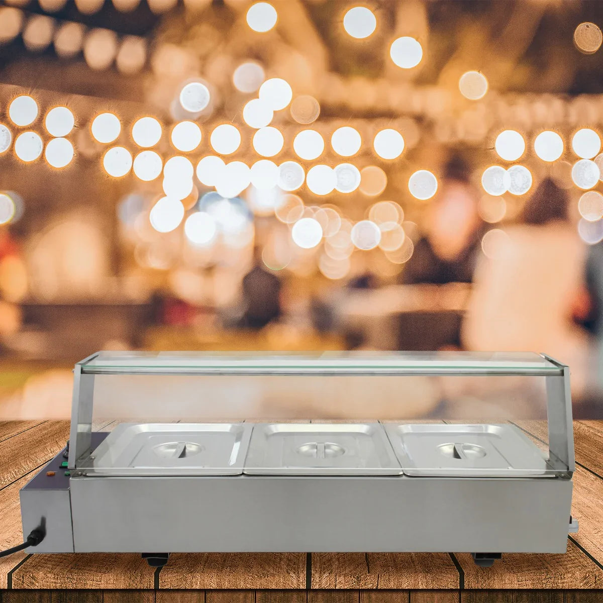 Stainless steel KuKoo 3 Pan Wet Well Bain Marie with clear lid, ideal for keeping food warm at events, set against a festive background