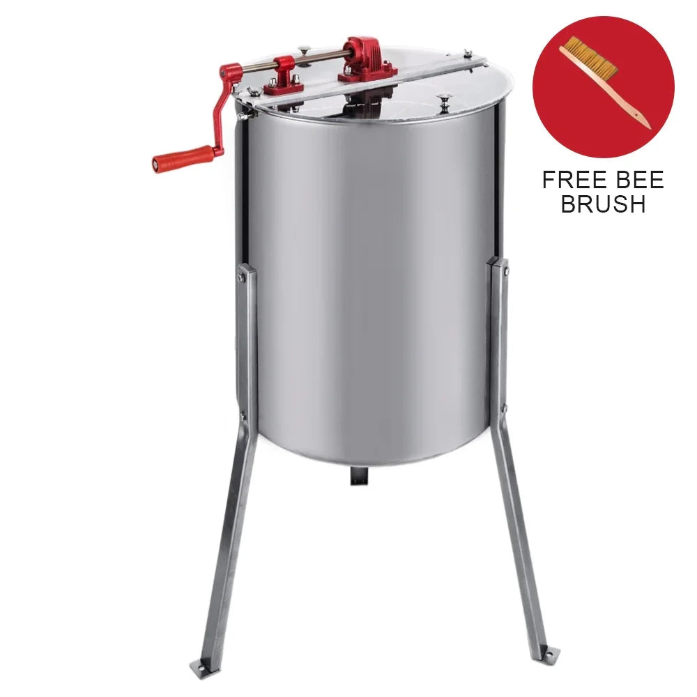 Stainless steel manual honey extractor with a red crank handle, sturdy legs, and a complimentary bee brush in the corner