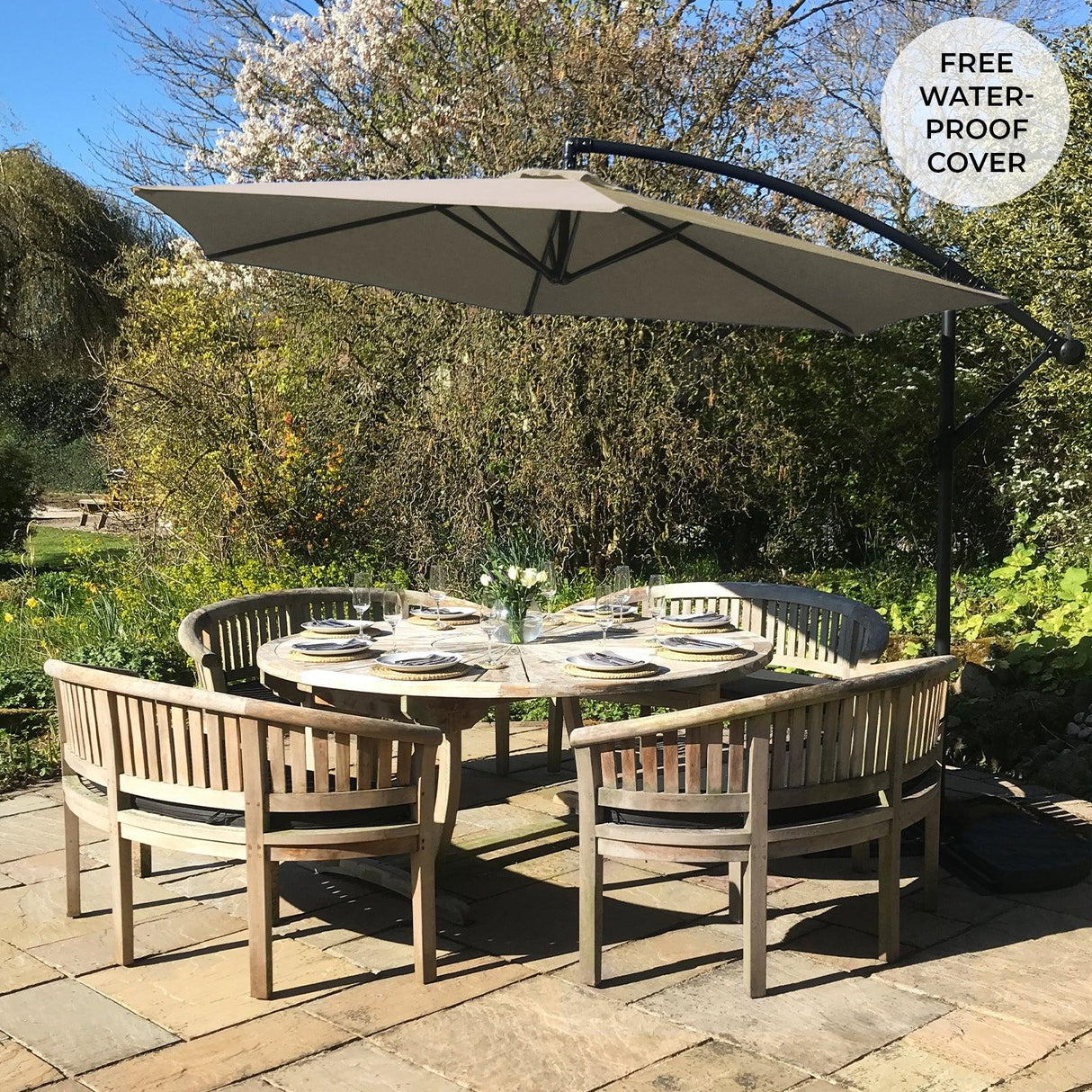 Beige cantilever parasol with a curved arm, providing shade over a round wooden dining table set in a garden, featuring a waterproof cover
