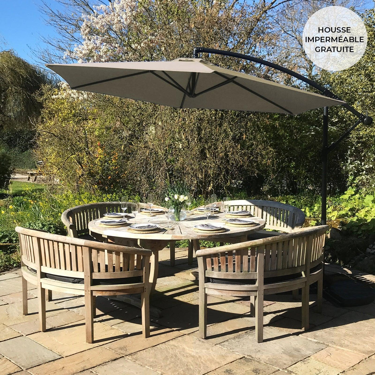 Beige cantilever parasol with a curved arm, providing shade over a round wooden dining table set in a garden setting