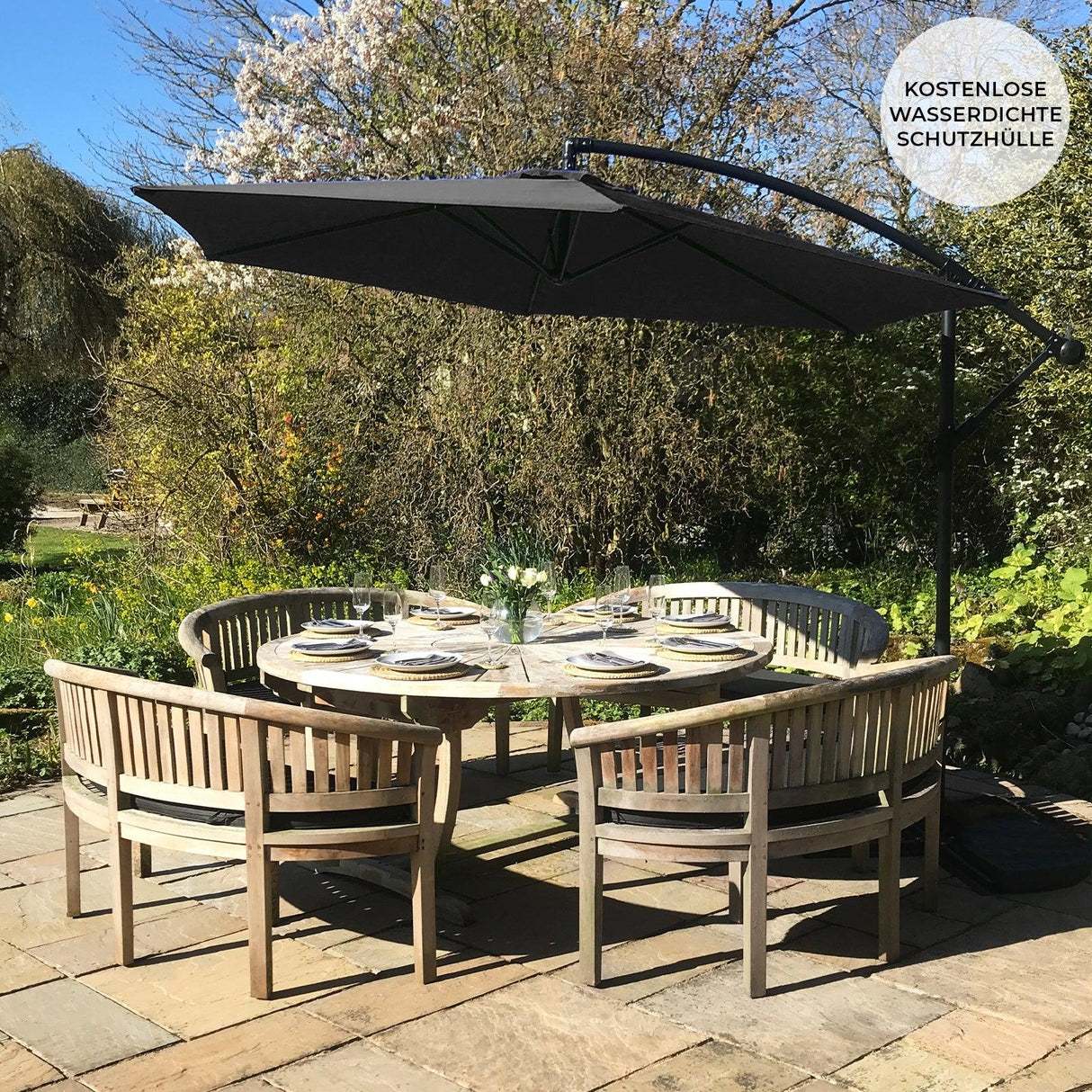 Black cantilever parasol with a sleek design, providing shade over a round wooden dining table set in a sunny garden setting