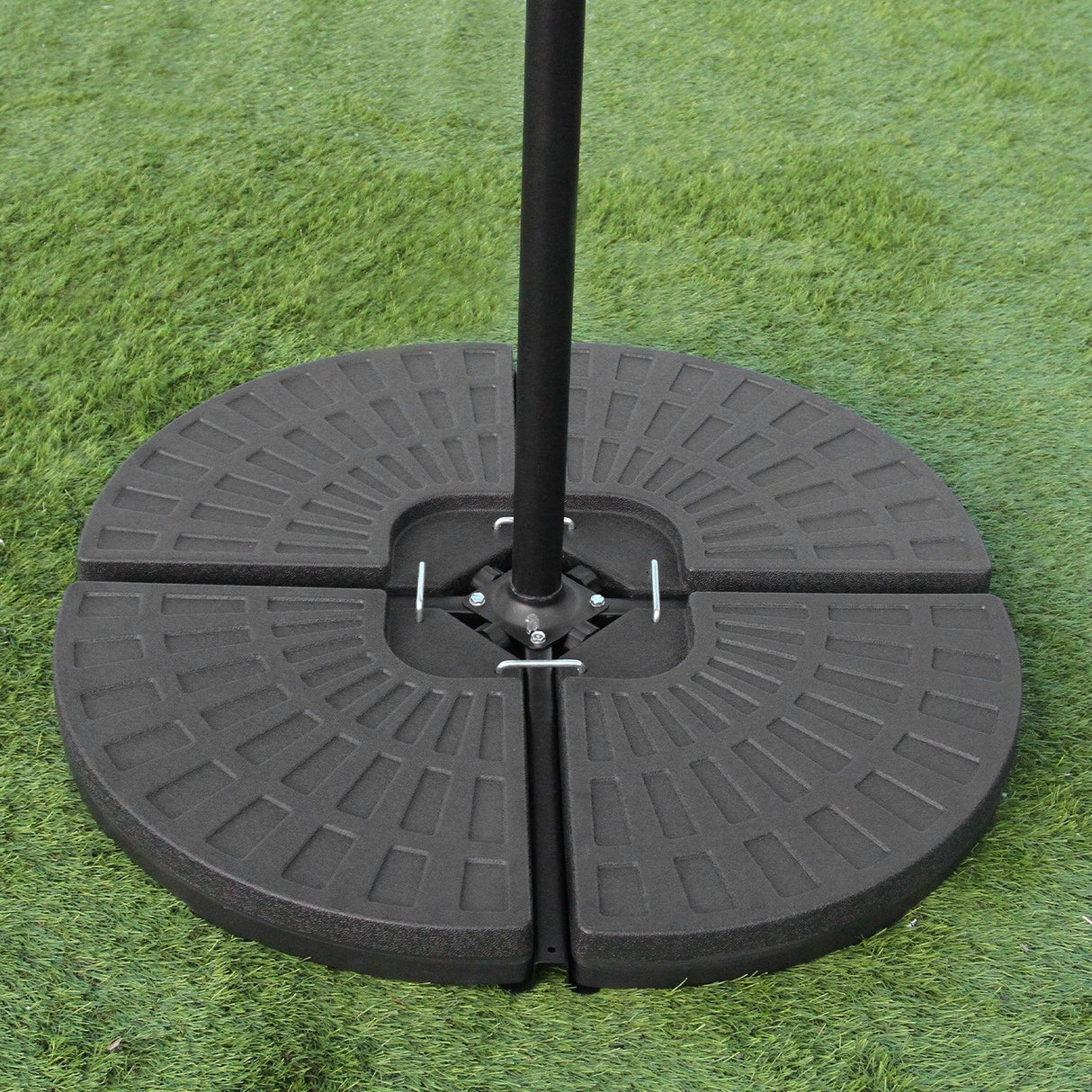 Black cantilever parasol base with a textured circular design, made of durable material, set on green grass for outdoor use
