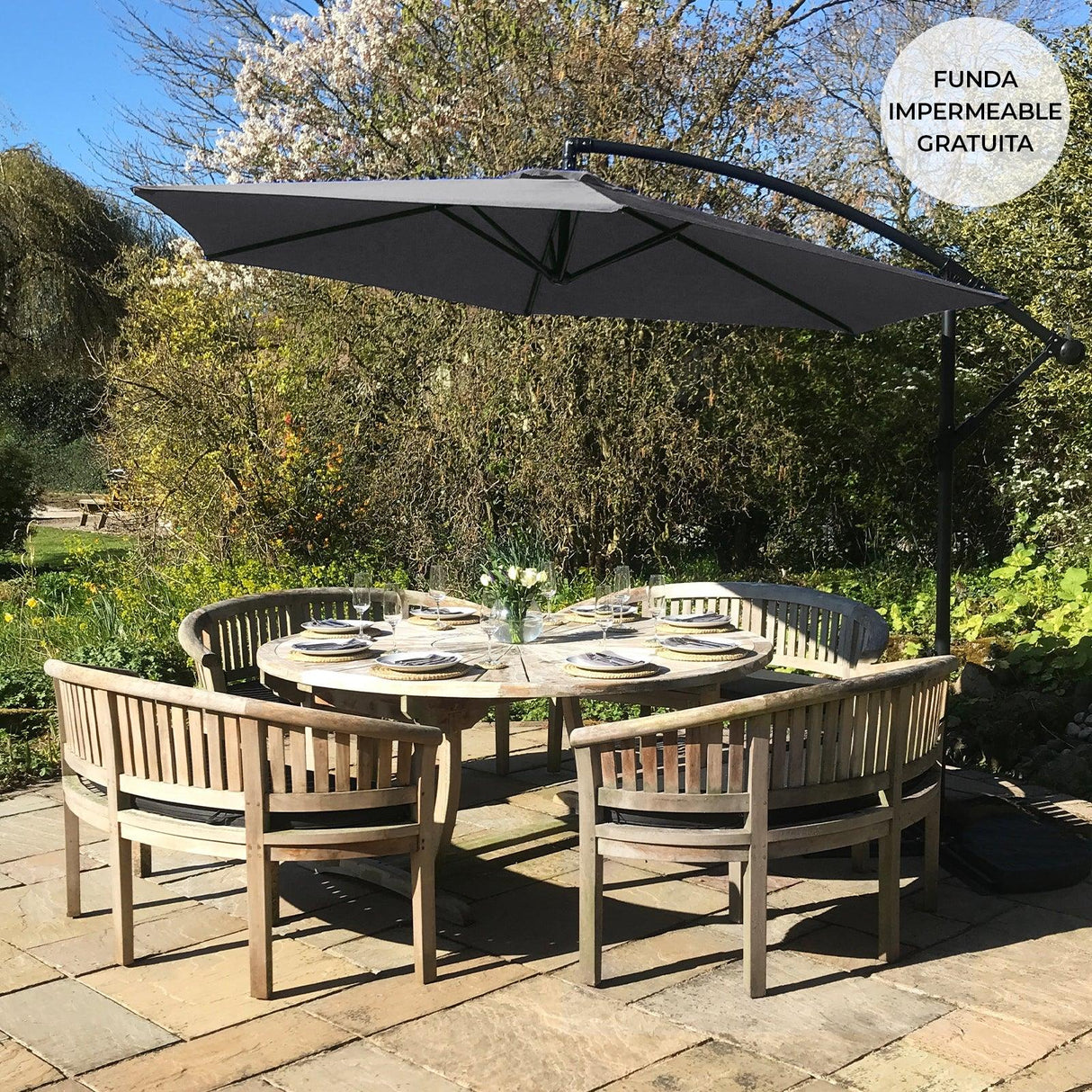 Grey cantilever parasol with a sleek design, providing shade over a round wooden dining table set in a lush garden setting