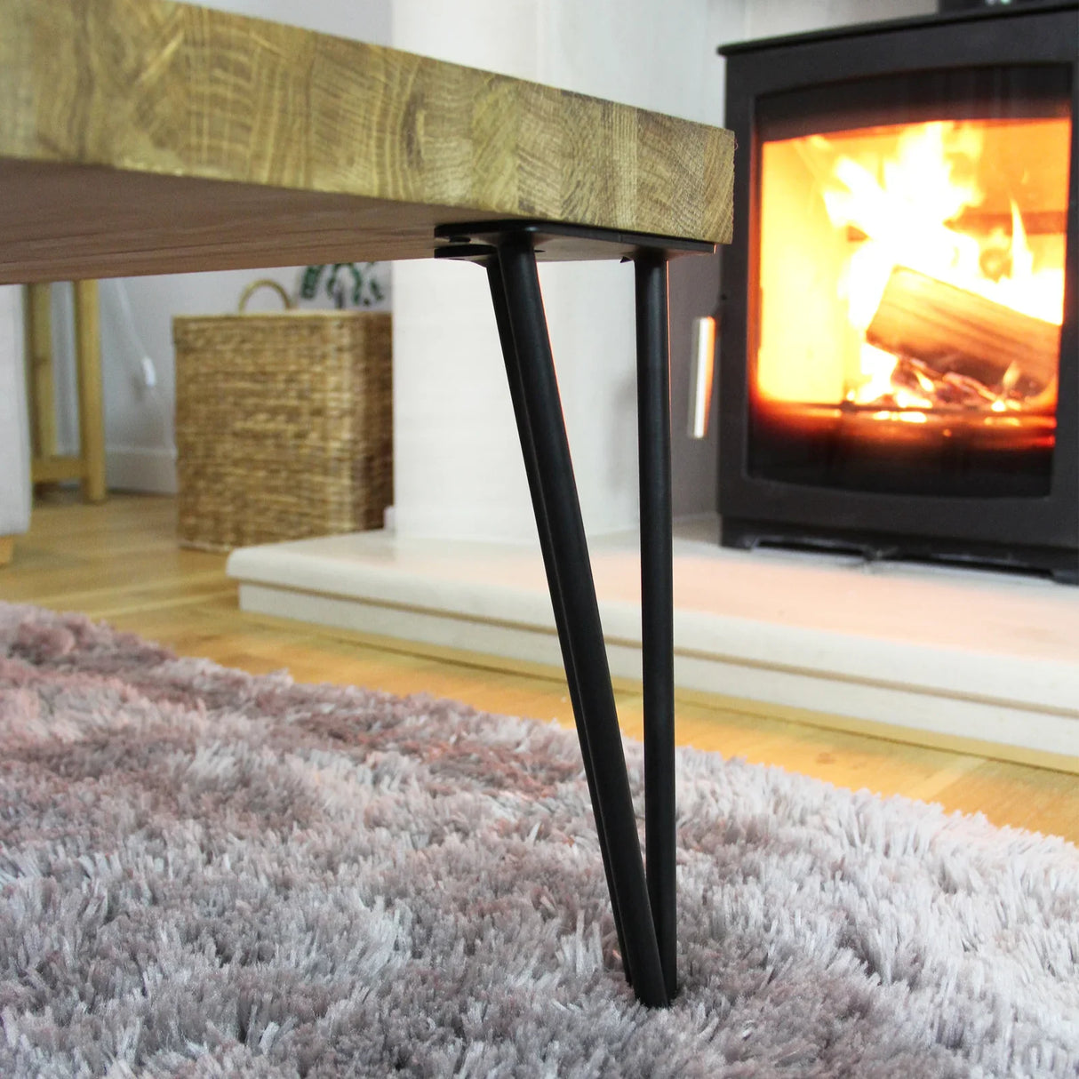 Black 12mm hairpin legs with a sleek three-prong design, supporting a wooden tabletop in a cozy, warm living room setting