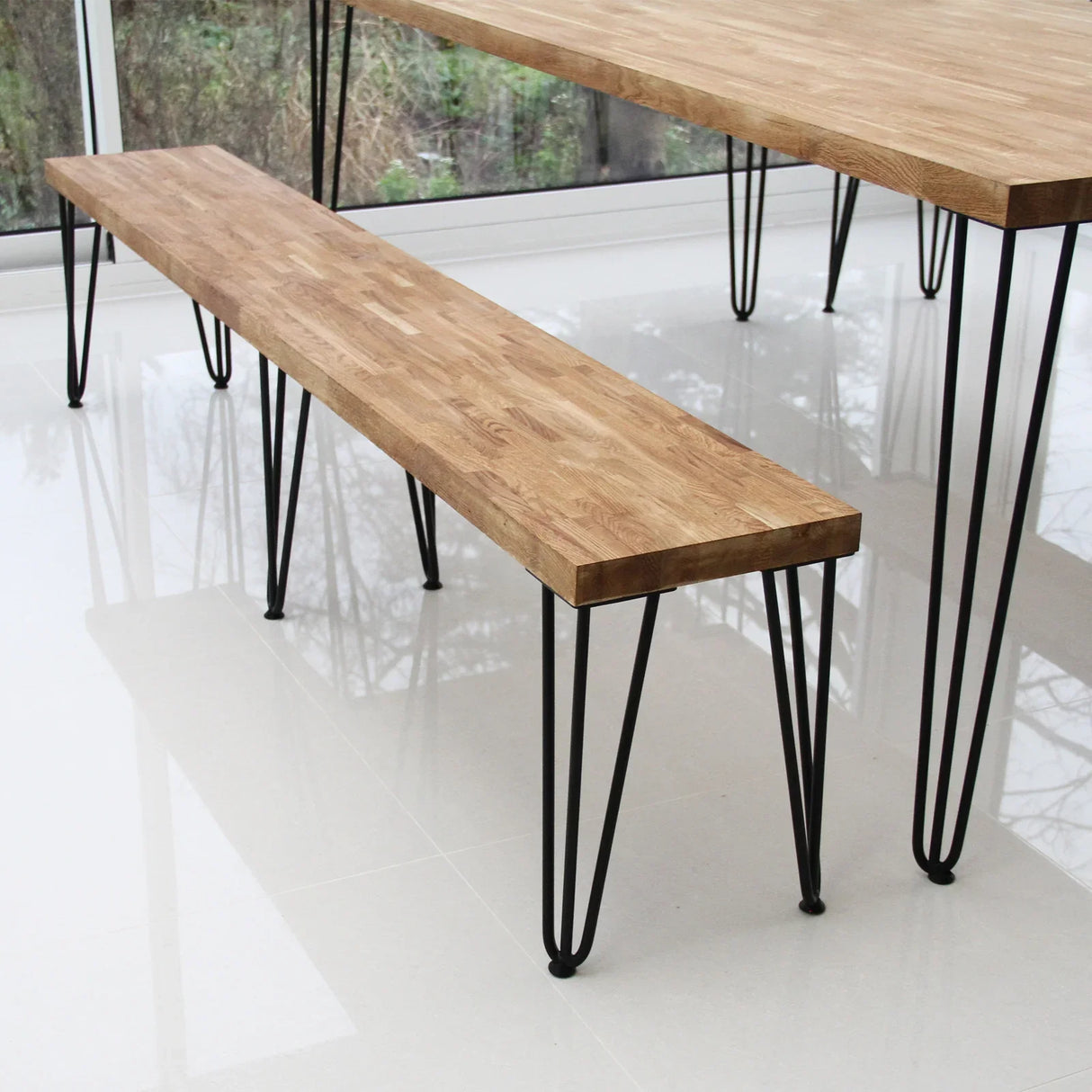 Black 12mm hairpin legs with three prongs supporting a wooden bench, showcasing a modern industrial design and sturdy construction
