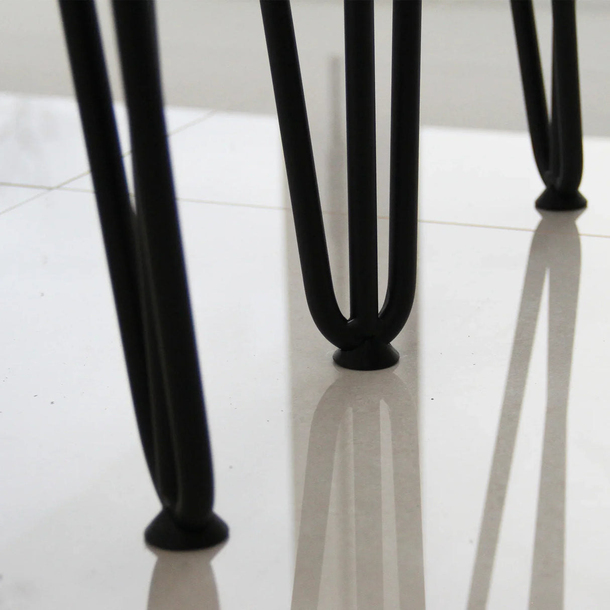 Black 12mm hairpin legs with a sleek three-prong design, showcasing a modern aesthetic and sturdy construction on a glossy surface