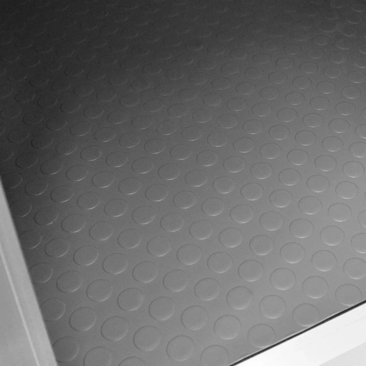 Textured rubber flooring of a small car dog pet crate, featuring a non-slip surface with circular patterns for added grip