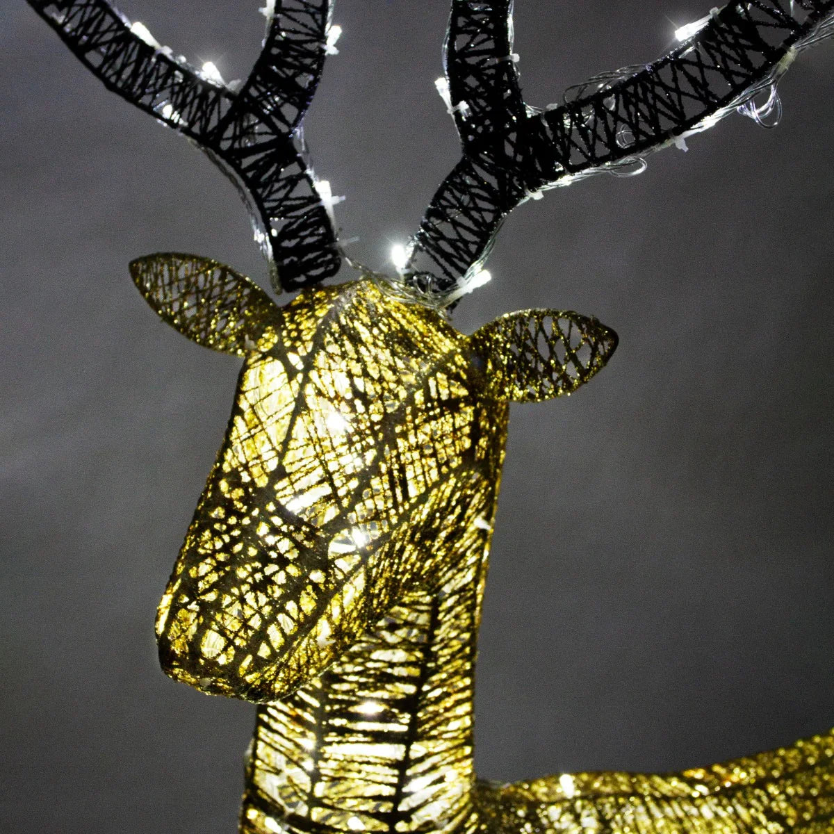 Gold stag reindeer with intricate wire design and twinkling lights, showcasing a festive and elegant holiday decoration