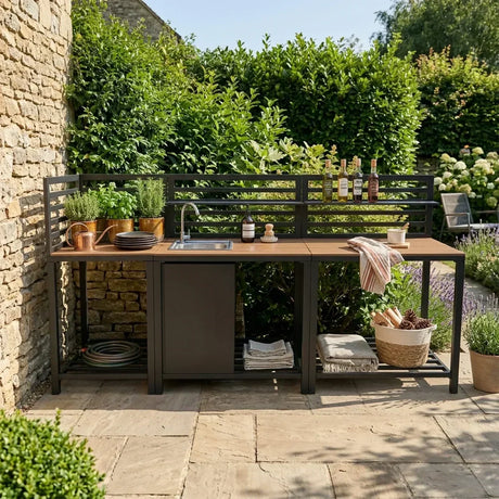 Stylish outdoor kitchen featuring a wooden countertop, sleek black metal frame, herb planters, and a modern sink surrounded by greenery