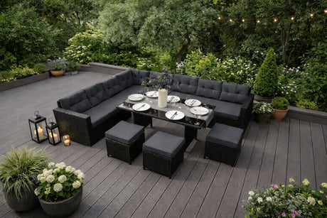 Stylish outdoor dining set with black cushioned seating, a glass table, and decorative plants, perfect for garden gatherings