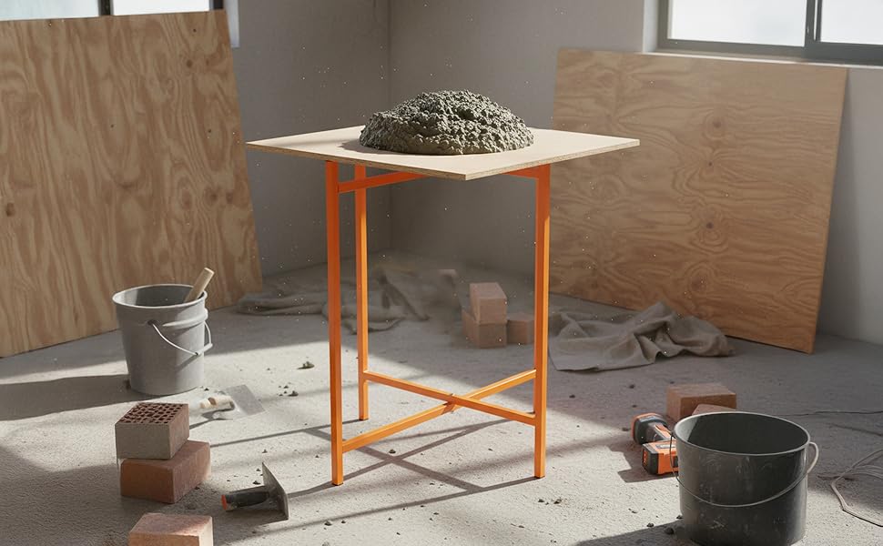 A sturdy orange mortar board stand supports a mound of wet concrete, surrounded by tools and building materials in a workshop setting