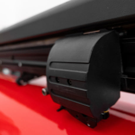 Close-up of a black, textured accessory mounted on a red surface, showcasing its sleek design and functional features for enhanced utility