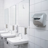 Sleek silver Maxblast automatic hand dryer mounted on a tiled bathroom wall, featuring a HEPA filter and modern design elements