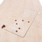 7-in-1 games table with a light oak finish, featuring a shuffleboard layout and game pieces in brown and cream colors