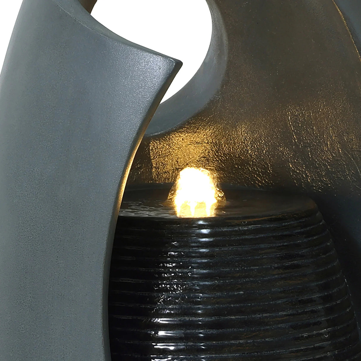 Sleek gray electric water feature with cascading falls, illuminated by a warm light, creating a tranquil ambiance in any space
