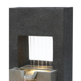 Sleek black stone electric water feature with cascading water, illuminated from below, creating a tranquil ambiance