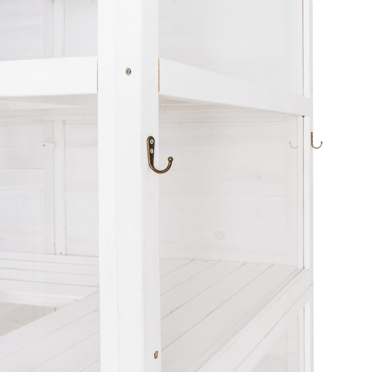 White Victorian greenhouse interior featuring wooden shelves, smooth surfaces, and decorative brass hooks for hanging plants