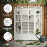 Victorian-style white greenhouse with glass panels, secure door latches, and two automatic vents, surrounded by potted plants