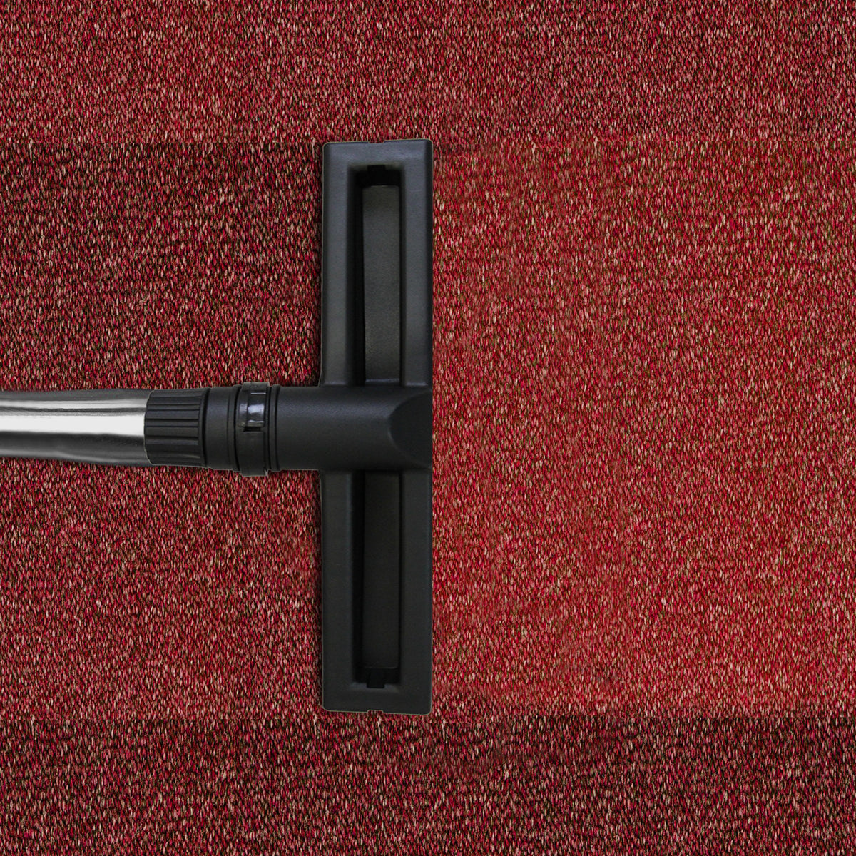 Black nozzle of a 90L Maxblast industrial vacuum on a textured red carpet, showcasing its wet and dry cleaning capabilities