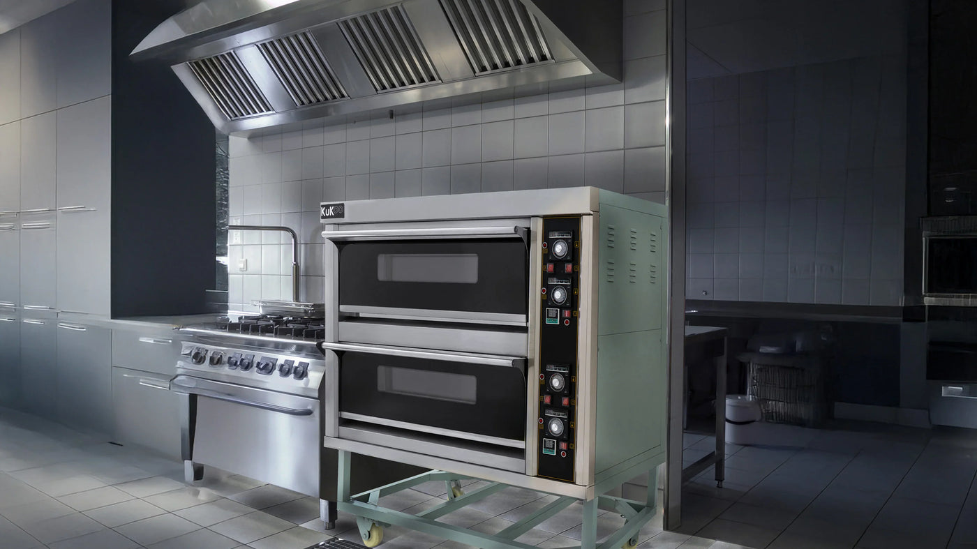 Modern commercial kitchen featuring a stainless steel double oven, gas range, and sleek cabinetry with a polished tile backdrop