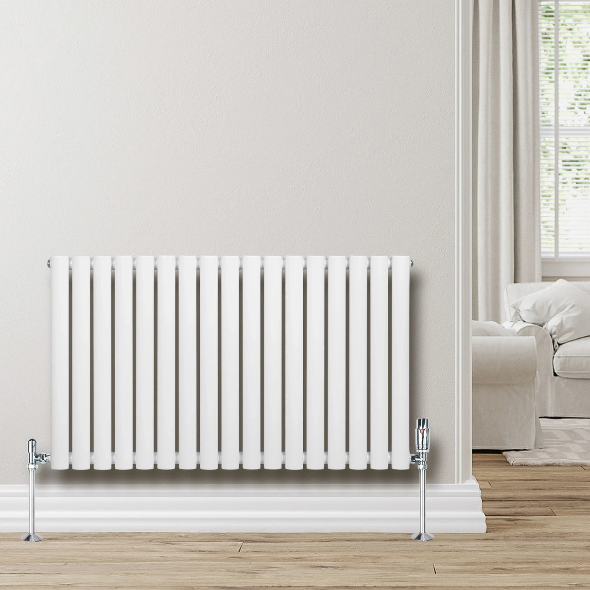 White oval single column radiator with chrome valves, 600mm x 1020mm, mounted on a light-colored wall in a cozy room setting