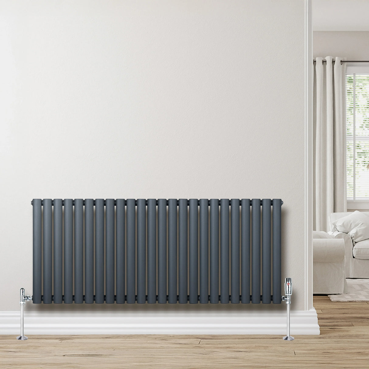 Oval single column radiator in anthracite grey, featuring sleek vertical lines and chrome valves, mounted on a light wall