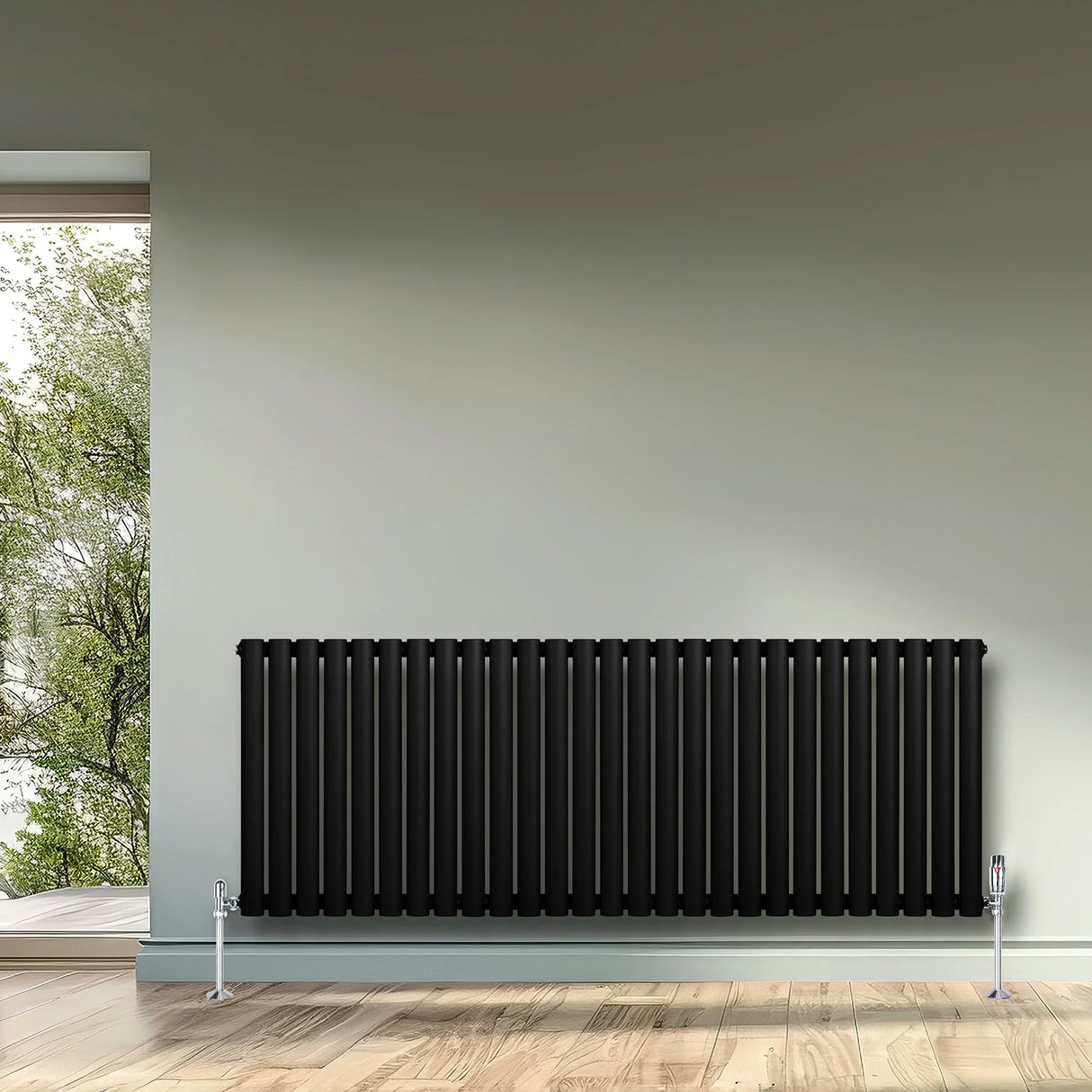 Sleek black oval single column radiator with chrome valves, mounted on a light grey wall, enhancing modern interior decor