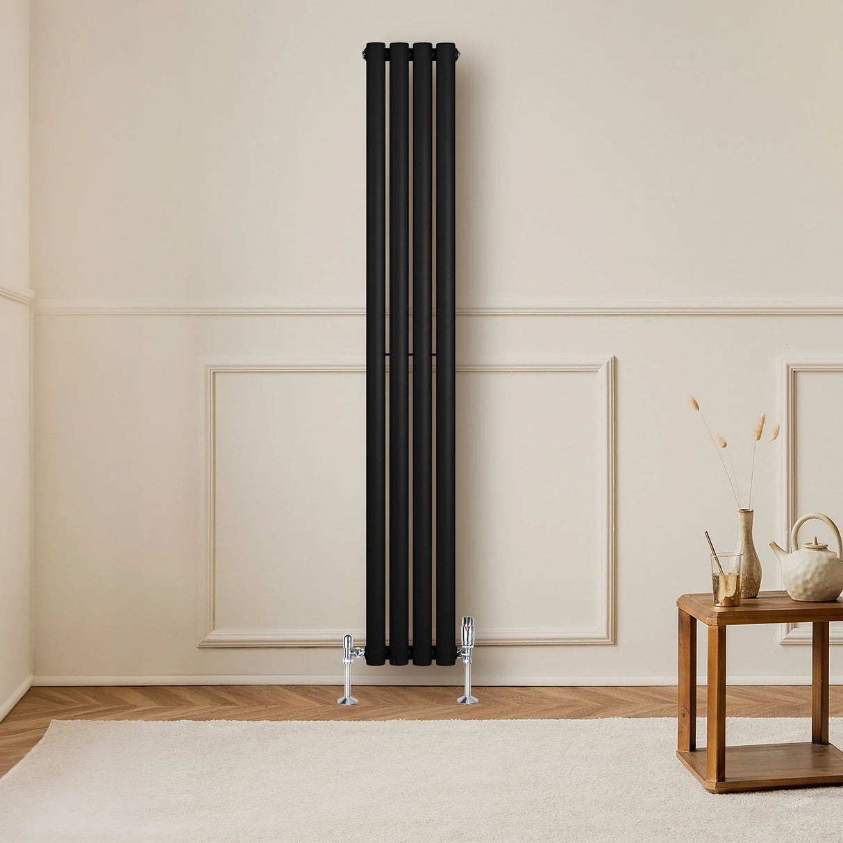 Sleek black oval single column radiator with valves, measuring 1600mm x 240mm, mounted on a light-colored wall in a modern room