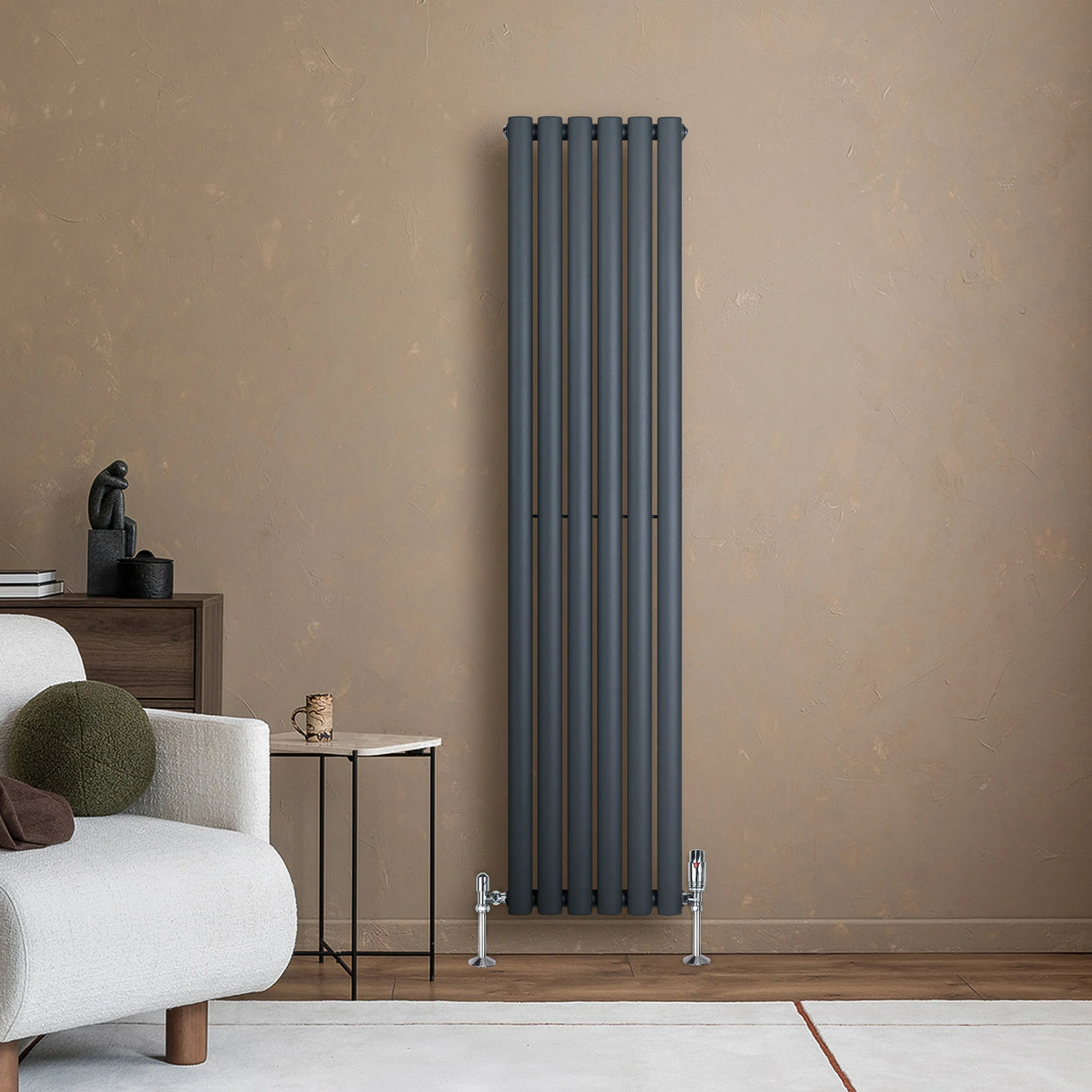 Anthracite grey oval single column radiator with sleek vertical lines, complemented by modern valves, set against a warm-toned wall