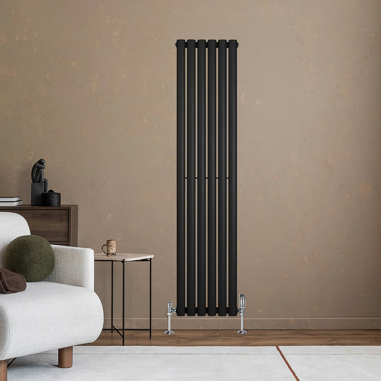 Sleek black oval single column radiator mounted on a textured wall, complemented by stylish valves and modern decor elements
