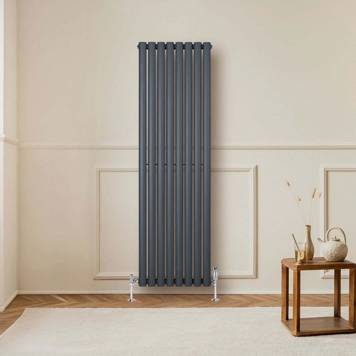 Oval single column radiator in anthracite grey, 1600mm x 480mm, mounted on a wall with stylish valves, enhancing modern decor