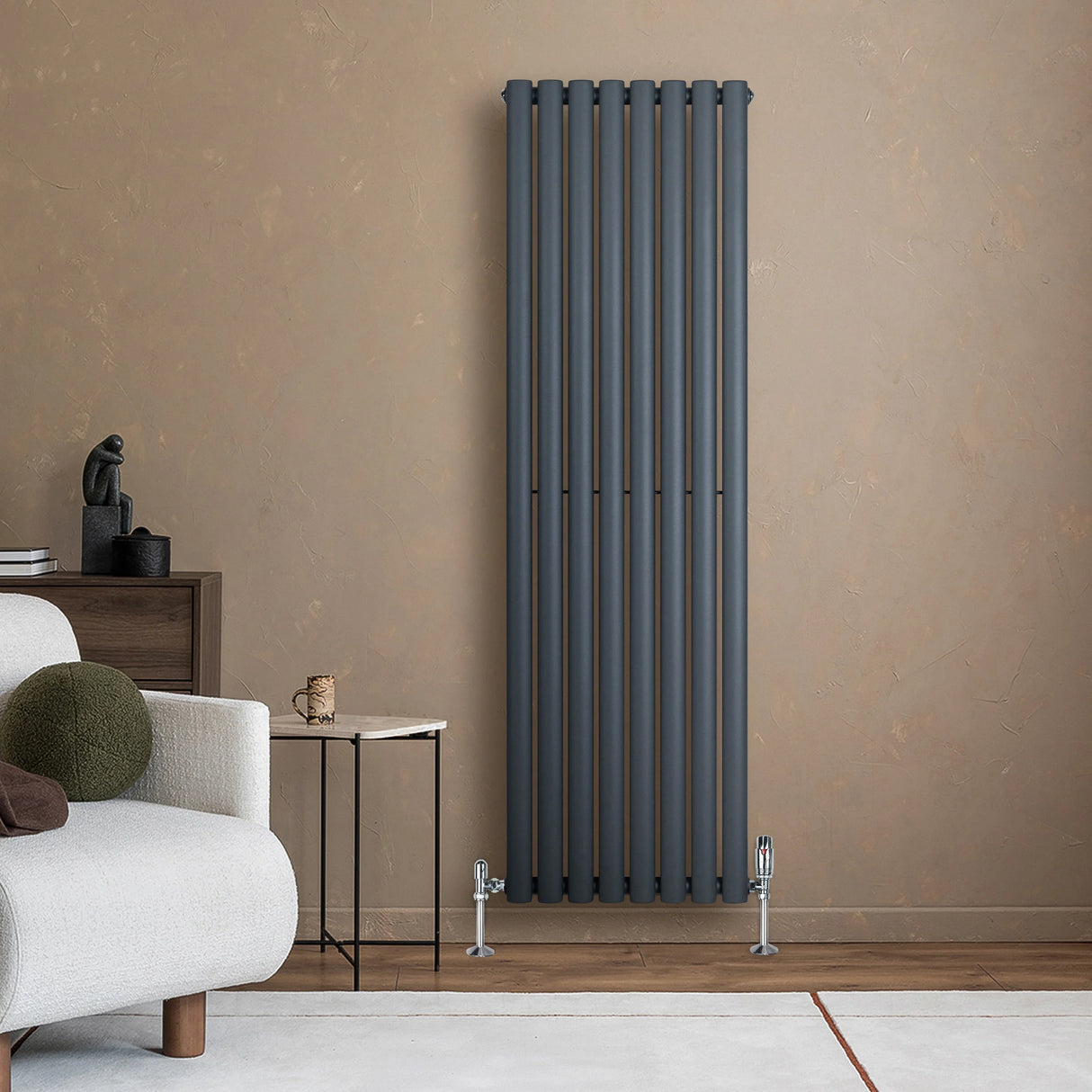 Oval single column radiator in anthracite grey, 1600mm x 480mm, mounted on a textured wall, with sleek valves and modern decor elements