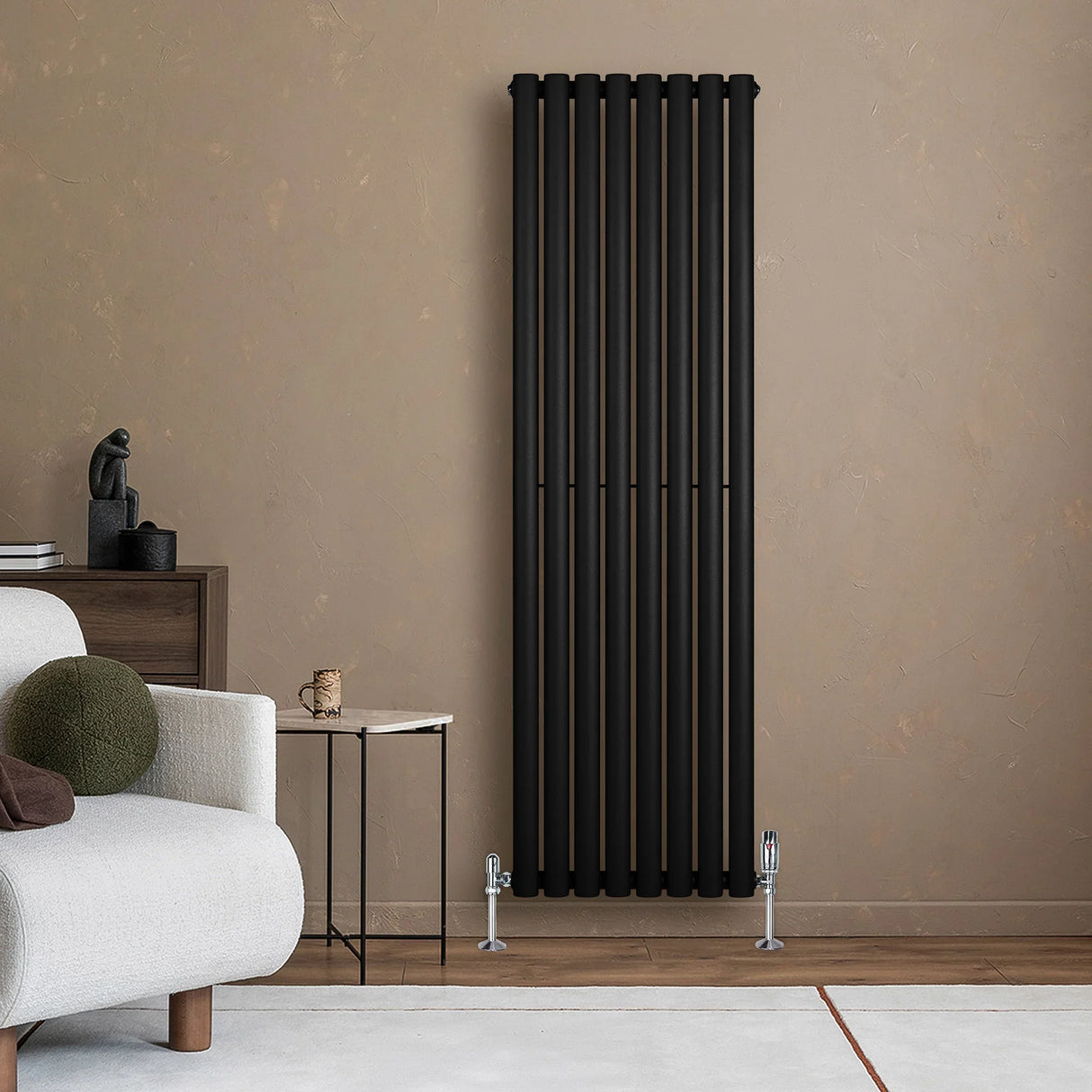 Sleek black oval single column radiator with vertical bars, positioned against a warm-toned wall, complemented by stylish valves