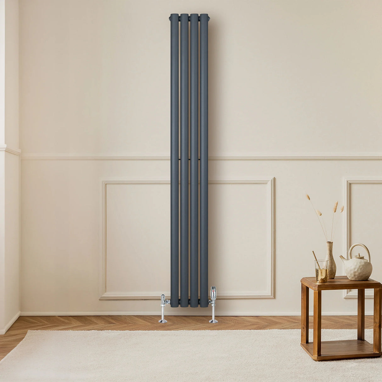 Sleek anthracite grey oval single column radiator with polished valves, positioned against a light-colored wall, enhancing modern decor