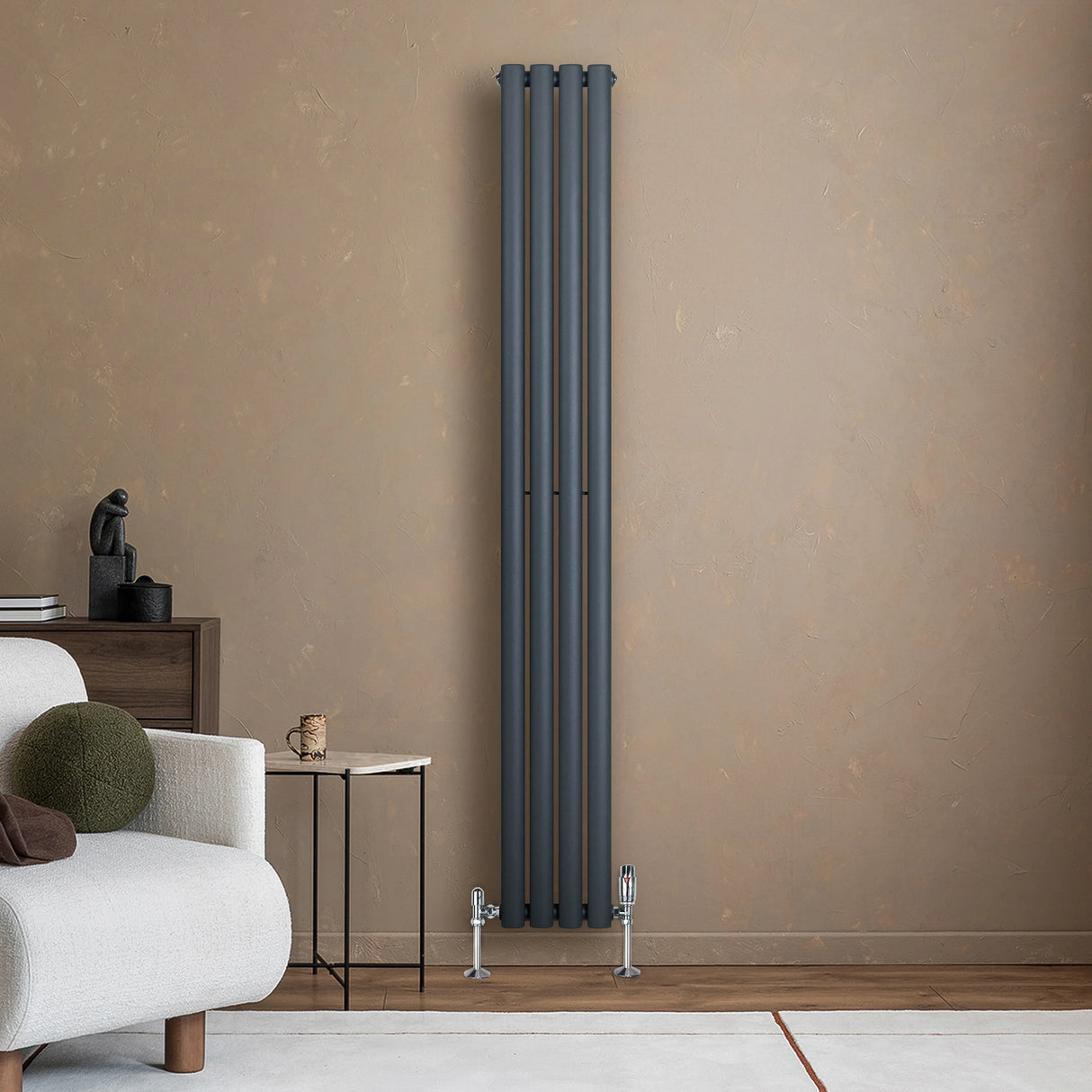 Sleek anthracite grey oval single column radiator with valves, standing tall against a textured beige wall in a modern living space