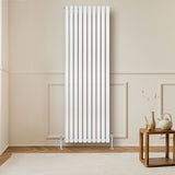 Sleek white oval single column radiator, 1800mm x 600mm, mounted on a wall in a modern room with wooden flooring and a decorative table