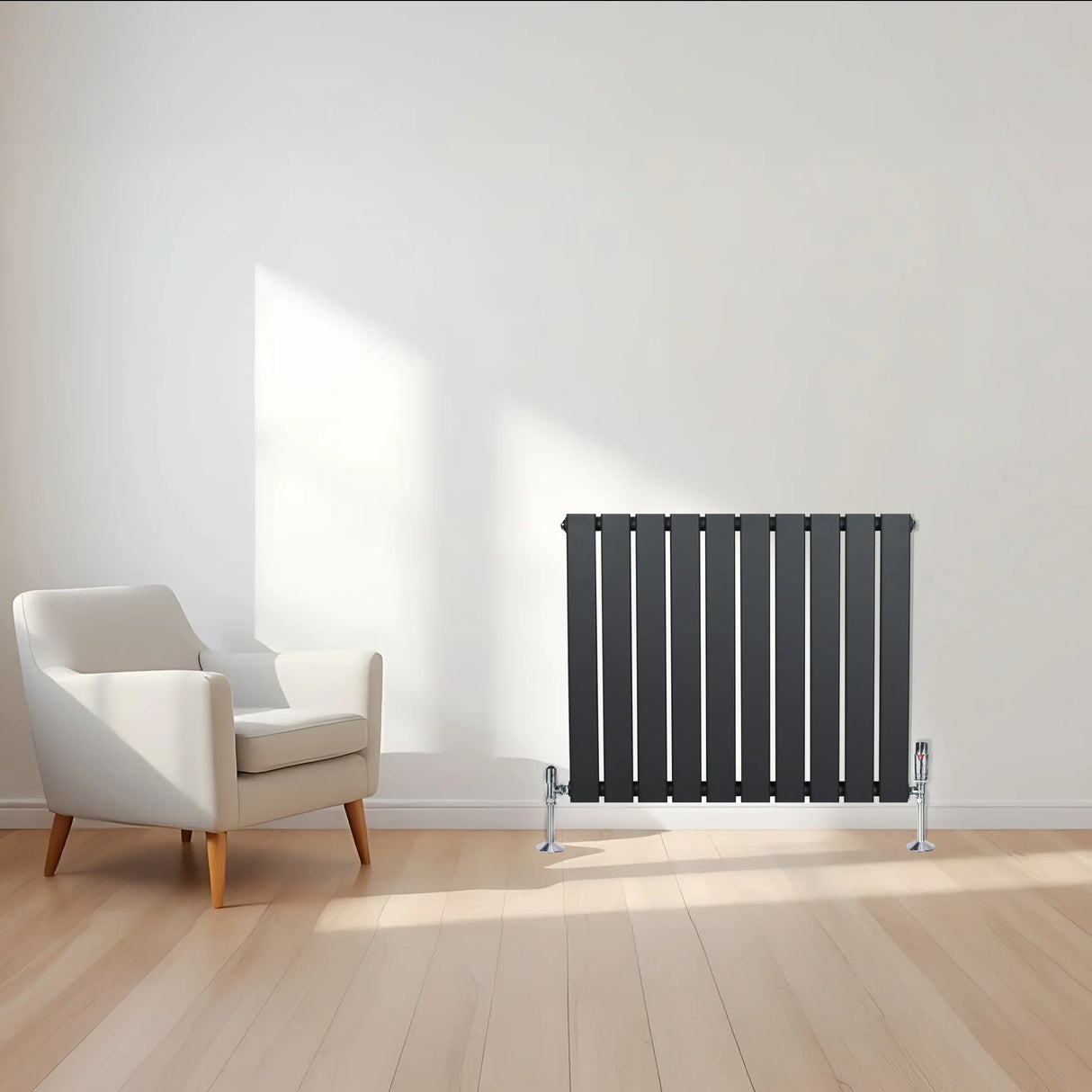 Flat single column radiator in anthracite grey, featuring sleek vertical panels, positioned beside a modern white armchair in a bright room