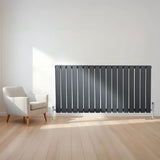 Flat single column radiator in anthracite grey, 600mm x 1190mm, with sleek vertical lines and modern valves, set against a light room backdrop