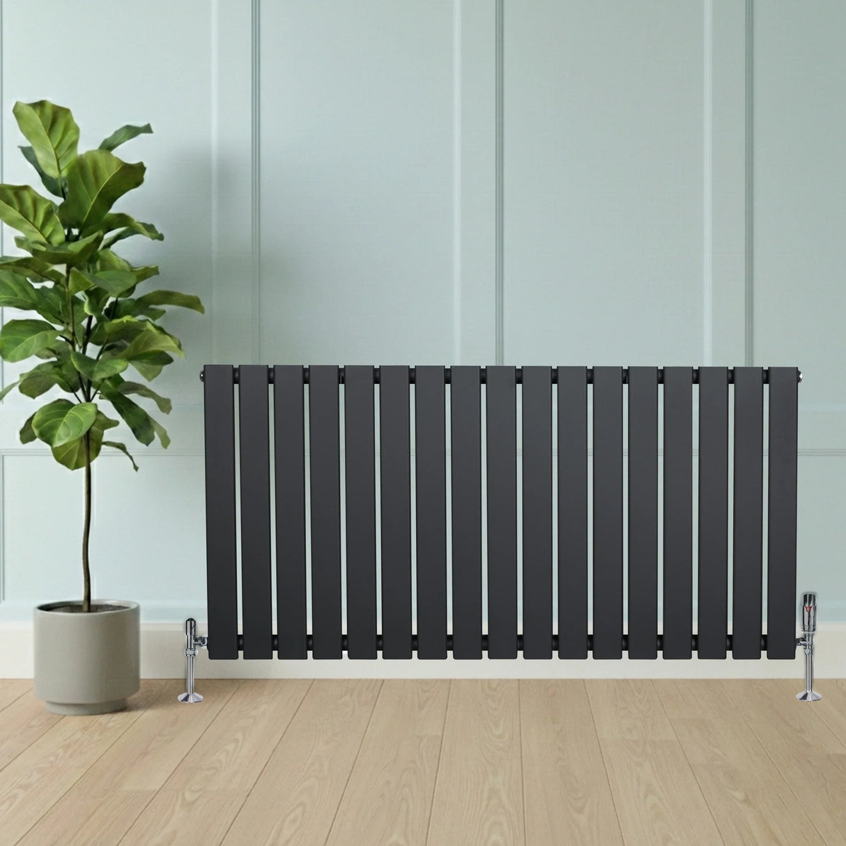 Flat single column radiator in anthracite grey, featuring sleek vertical bars and chrome valves, positioned beside a potted plant on wooden flooring