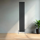 Sleek black flat single column radiator, 1600mm x 280mm, with chrome valves, positioned against a modern interior wall and wooden floor