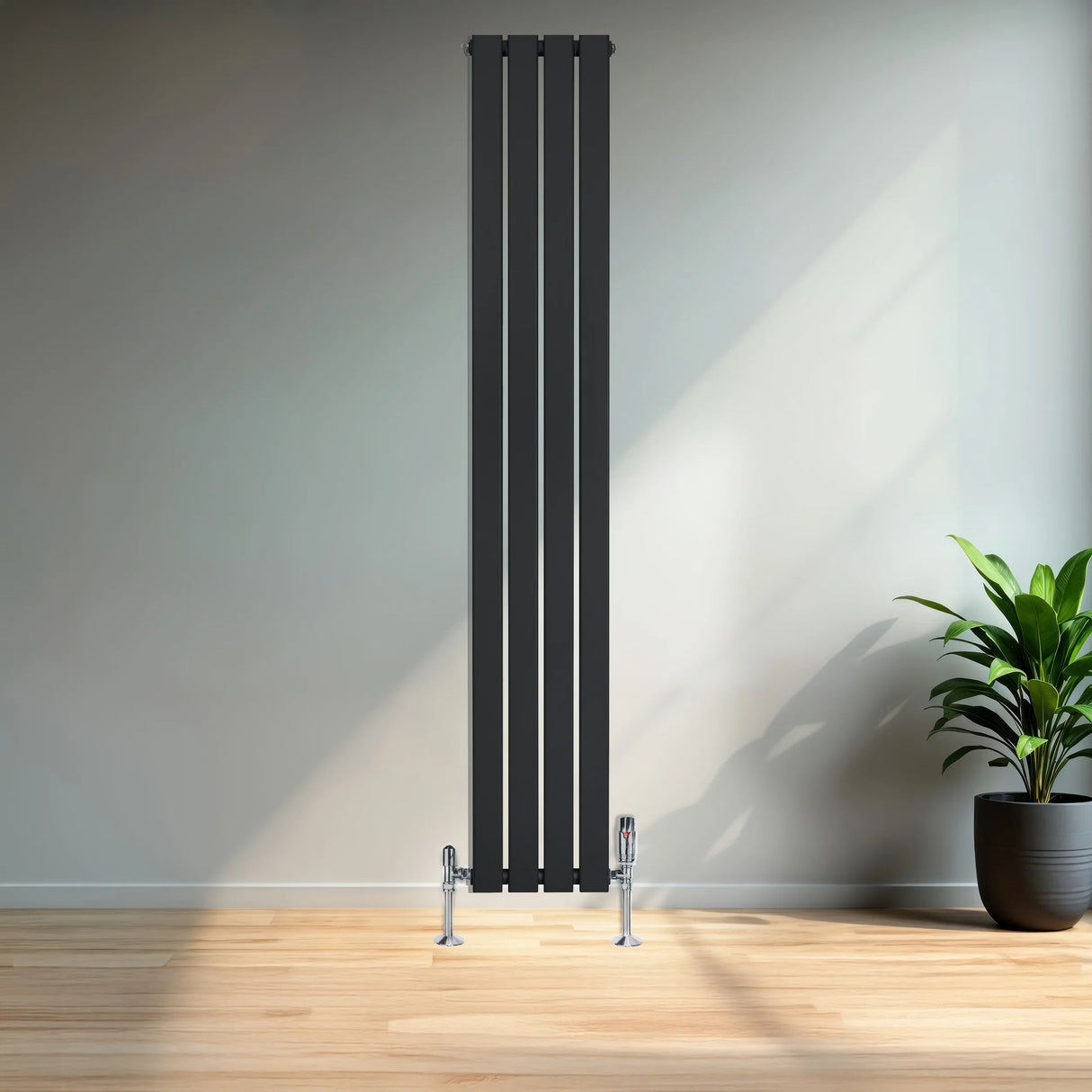 Sleek black flat single column radiator with chrome valves, standing tall against a modern interior backdrop with natural light
