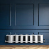 Traditional white 4 column radiator with valves, showcasing a sleek design against a deep blue wall and wooden flooring
