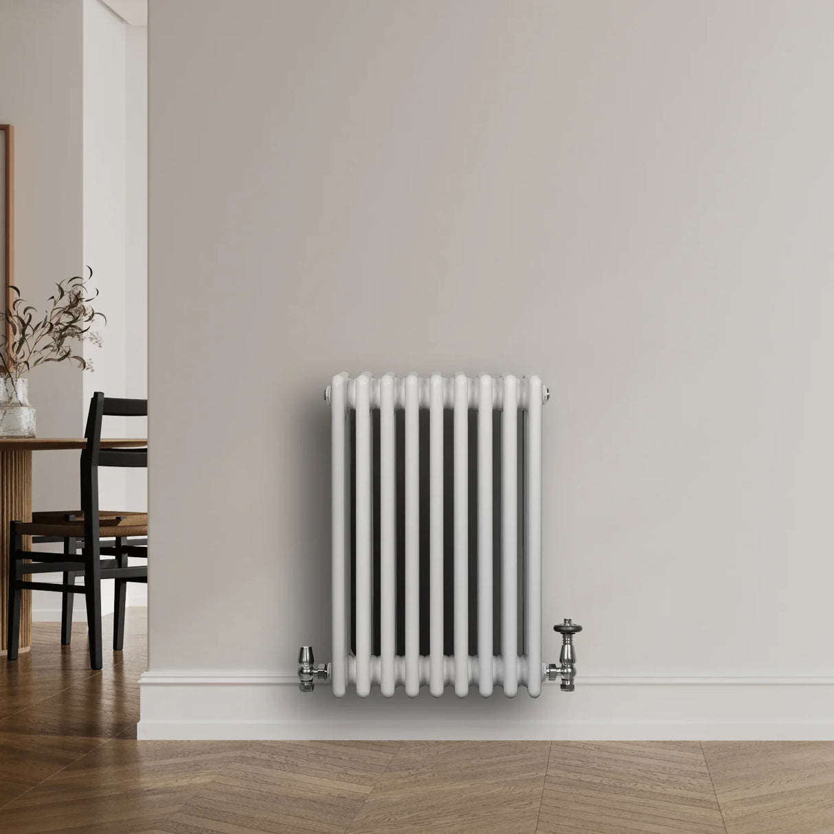 Traditional white 4 column radiator with smooth, glossy finish and chrome valves, mounted on a light-colored wall in a modern interior