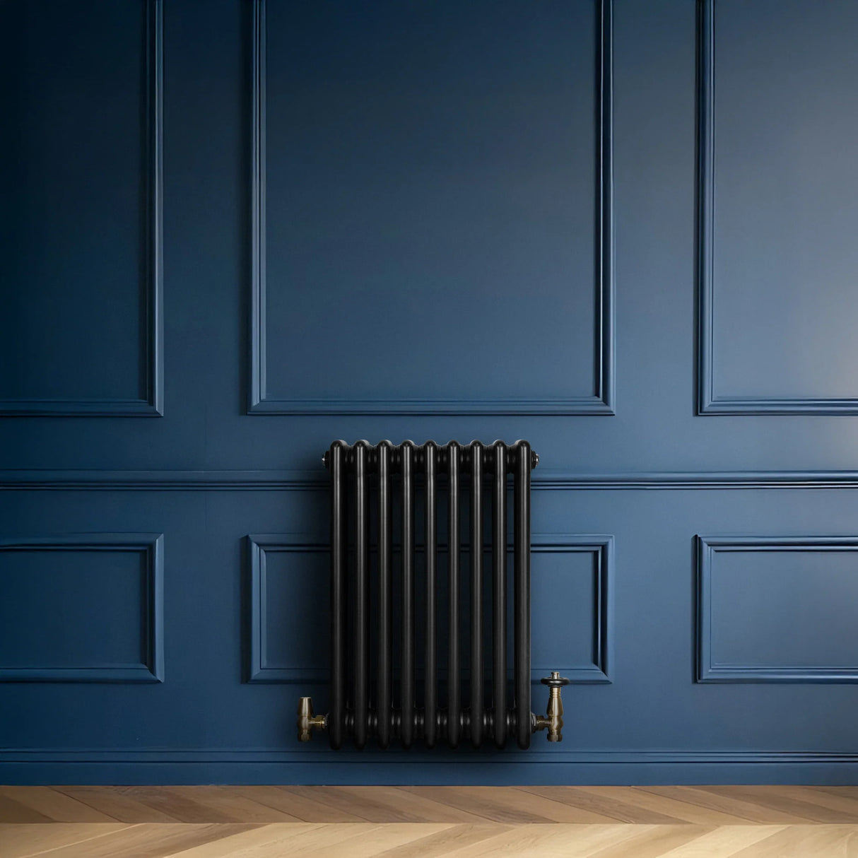 Traditional black 4 column radiator mounted on a deep blue wall, featuring brass valves and a sleek, modern design
