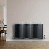 Traditional anthracite grey 4 column radiator with sleek vertical lines, mounted on a light wall, complementing modern decor