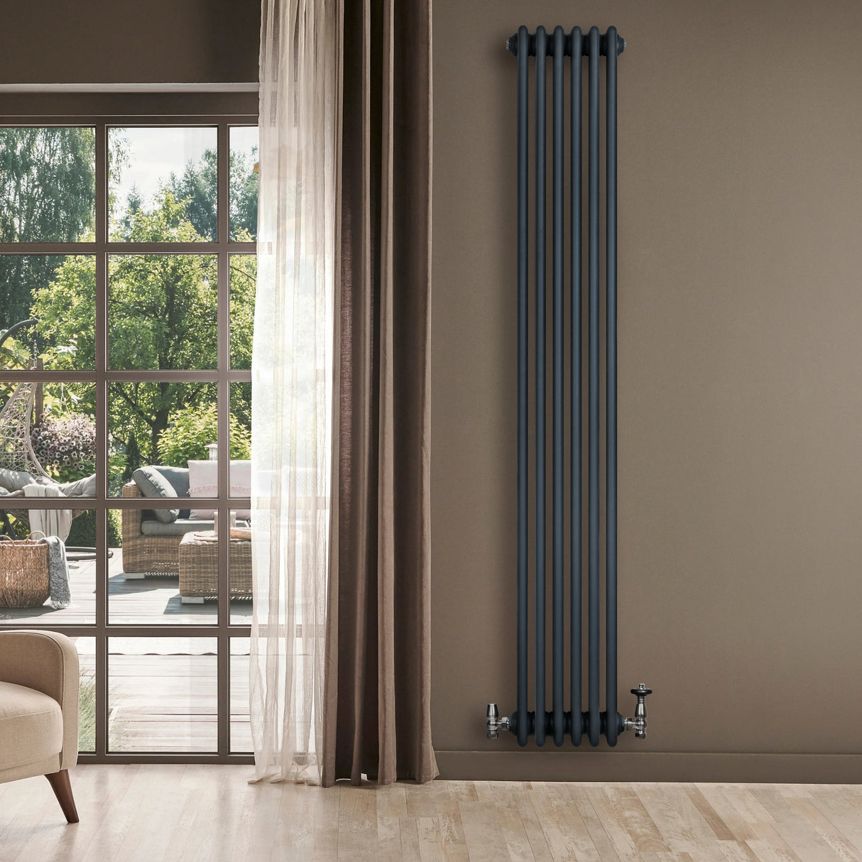 Traditional anthracite grey 4 column radiator with sleek vertical design, mounted on a wall beside large windows and curtains